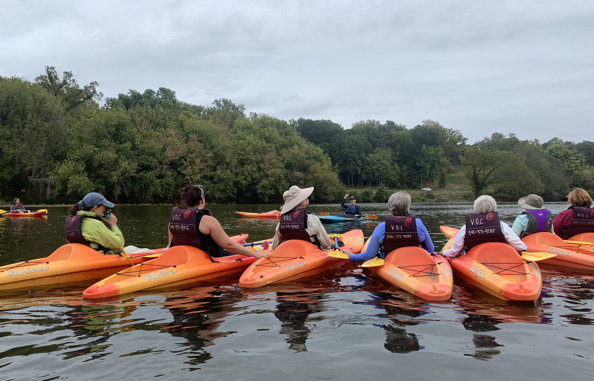 Women in orange kayaks on the river